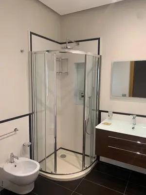 a bathroom with a shower and a toilet and a sink at Villa Rubino in Isola delle Femmine