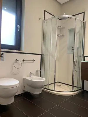 a bathroom with a shower and a toilet and a sink at Villa Rubino in Isola delle Femmine