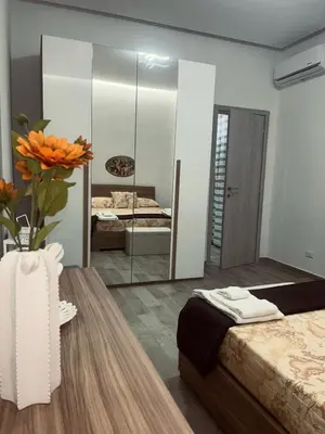 a bedroom with two beds and a vase with flowers on a table at Silvia's House in Castellammare del Golfo