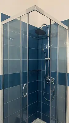a bathroom with a shower with blue tiles at Silvia's House in Castellammare del Golfo