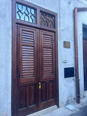 a large wooden door on the side of a building at Silvia's House in Castellammare del Golfo