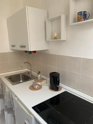 a kitchen with white cabinets and a sink at A casa di Elvira in Palermo