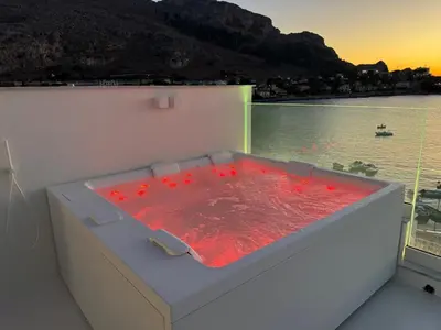 a hot tub on a boat with a view of the water at Attico sul Mare - Suite & Spa in Palermo