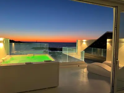 a room with a view of the ocean at sunset at Attico sul Mare - Suite & Spa in Palermo