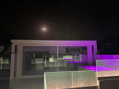 a building with purple lights on a balcony at night at Attico sul Mare - Suite & Spa in Palermo