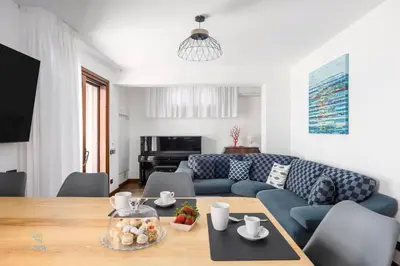 a living room with a blue couch and a table at Verosicily Villa Barcellona in Terrasini