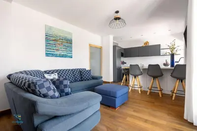 a living room with a blue couch and a kitchen at Verosicily Villa Barcellona in Terrasini