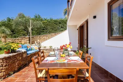 a table and chairs on the patio of a house at Verosicily Villa Barcellona in Terrasini