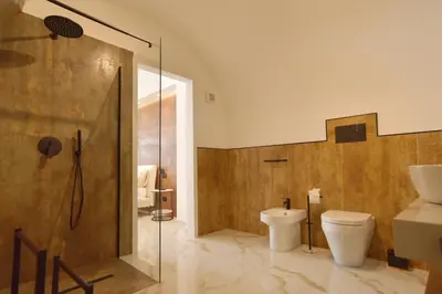 a bathroom with a toilet and a glass shower at FLA' Suite Deluxe in Terrasini