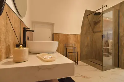 a bathroom with a white sink and a shower at FLA' Suite Deluxe in Terrasini