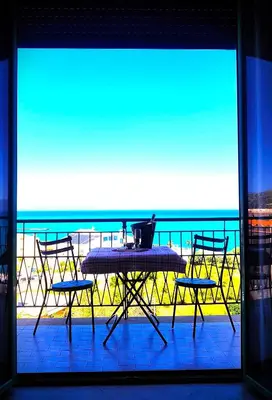 a table and chairs on a balcony with a view of the ocean at La Finestra sul Golfo in Castellammare del Golfo
