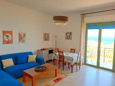 a living room with a blue couch and a table at La Finestra sul Golfo in Castellammare del Golfo