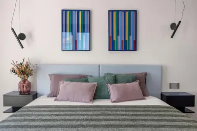 a bedroom with a bed with three pictures on the wall at Villa Adler Nature&Relax in Scopello