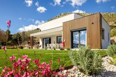 a house in a garden with flowers at Villa Adler Nature&Relax in Scopello