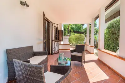 a living room with wicker chairs and a table at Villetta Milù in Palermo