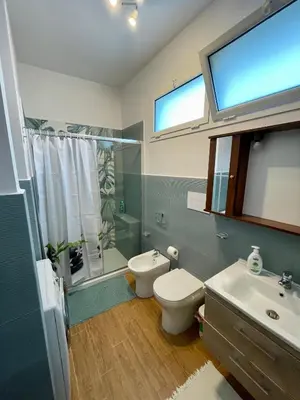 a bathroom with a toilet and a sink and a window at Bellavista in Santa Flavia