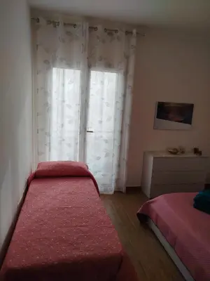 a bedroom with a bed and a window with curtains at Bellavista in Santa Flavia