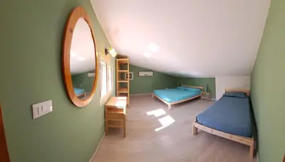 a attic room with two beds and a mirror at Villa Agae in Trabia