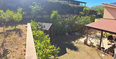 a backyard with a garden and a house at Villa Agae in Trabia