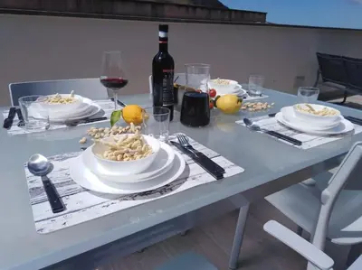 a table with plates of food and a bottle of wine at A 2 passi dal castello ,appartamento con veranda in Castellammare del Golfo