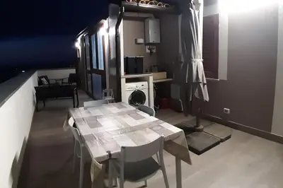 a table and chairs in a room with a kitchen at A 2 passi dal castello ,appartamento con veranda in Castellammare del Golfo