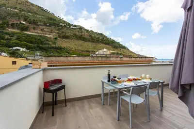 a table and chairs on a balcony with a view at A 2 passi dal castello ,appartamento con veranda in Castellammare del Golfo