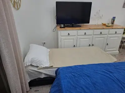a white dresser with a remote control and a vase at Ricky House in Palermo