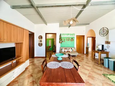 a living room with a wooden table and a tv at Tri Ri Coppe in Cinisi