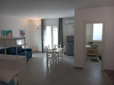 a living room with a table and a dining room at Villa Costa Mondello in Palermo