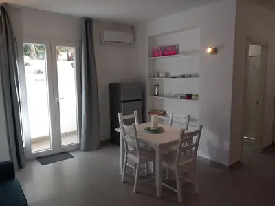 a dining room with a table and chairs and a refrigerator at Villa Costa Mondello in Palermo