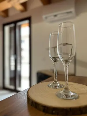 two wine glasses sitting on top of a wooden table at Calatafimi Rocca Home in Palermo