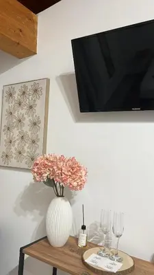 a vase with flowers on a table with wine glasses at Calatafimi Rocca Home in Palermo