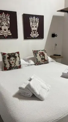a white towel sitting on top of a bed at Calatafimi Rocca Home in Palermo