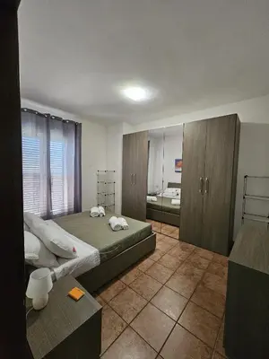 a bedroom with a bed and wooden cabinets at Nika Holiday Home in Casteldaccia
