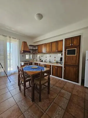 a kitchen with a table and chairs and a refrigerator at Nika Holiday Home in Casteldaccia