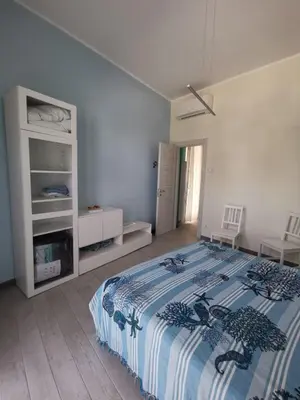 a bedroom with a bed with a blue and white blanket at Casa vacanze Haliotis in Isola delle Femmine