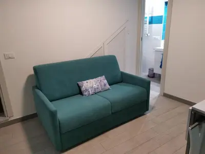 a green couch with a pillow on it in a living room at Casa vacanze Haliotis in Isola delle Femmine