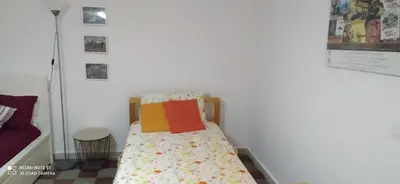 a small bed in a room with a white wall at Star Apartment at the Cathedral in Palermo