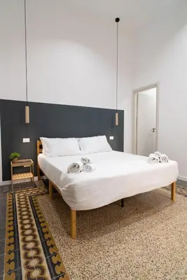 a bedroom with a large bed with a black wall at Picciridda Rooms in Palermo