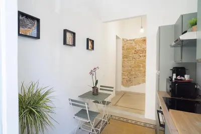 a kitchen with white walls and a table with a plant at Picciridda Rooms in Palermo