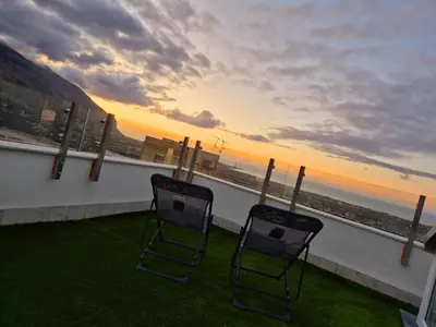 two chairs on a balcony with a view of the ocean at Panoramica Via Villa in Carini