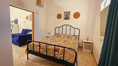 a bedroom with a bed and a blue couch at Panoramica Via Villa in Carini