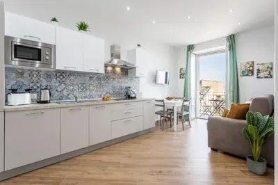 a kitchen with white cabinets and a living room at Sant'Erasmo luxury home in Palermo