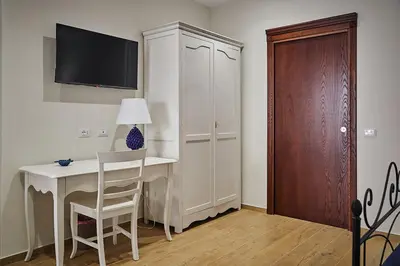 a room with a desk and a cabinet with a tv at Trinacria Caccamo - Luxury Rooms in Caccamo