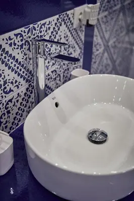 a white sink in a bathroom with a patterned wall at Trinacria Caccamo - Luxury Rooms in Caccamo