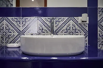 a sink in a bathroom with blue and white tiles at Trinacria Caccamo - Luxury Rooms in Caccamo