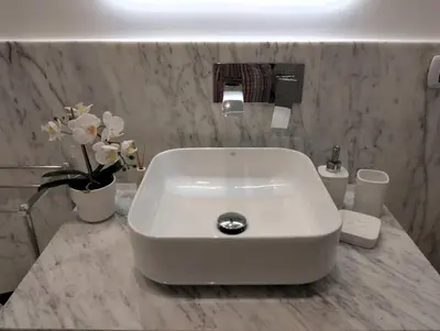 a white sink in a bathroom with flowers on a counter at Lily Suite 10 in Palermo