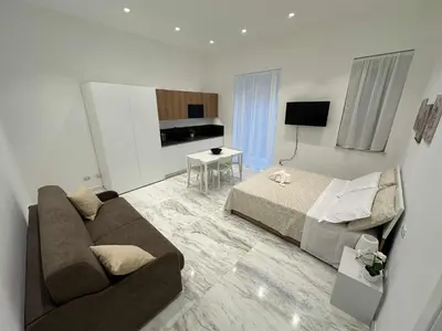 a living room with a couch and a bed at Lily Suite 10 in Palermo