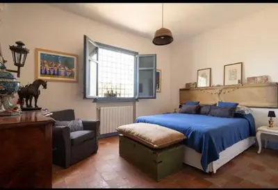 a bedroom with a blue bed and a chair at VILLA AZUL in Castellammare del Golfo