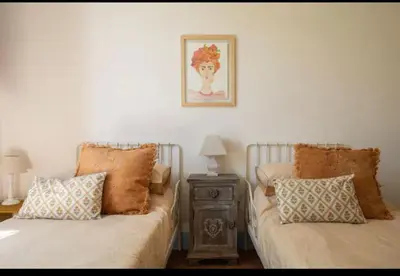 a bedroom with two beds and a table with a picture at VILLA AZUL in Castellammare del Golfo